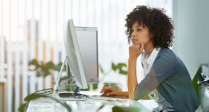 young woman reads something on her desktop computer