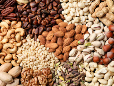 Image of nuts, including almonds, pistachios, walnuts, and peanuts, all staged together